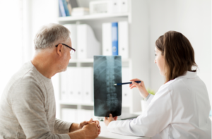 doctor showing x-ray of spine to senior man at hospital