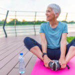 Woman on a yoga mat to relax outdoor. Senior lady prefers healthy lifestyle